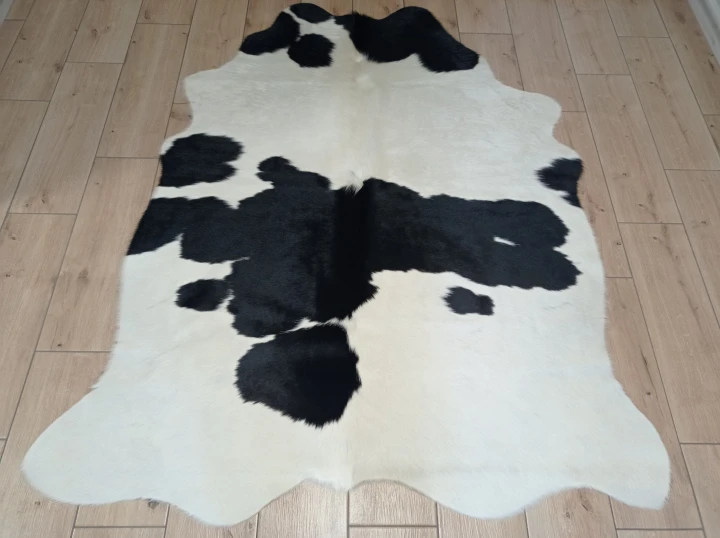 Naturalna skóra bydlęca ŁACIATA CZARNO-KREMOWA 170x140 cm rozłożona w dużym salonie  - dekoracyjneskory.pl