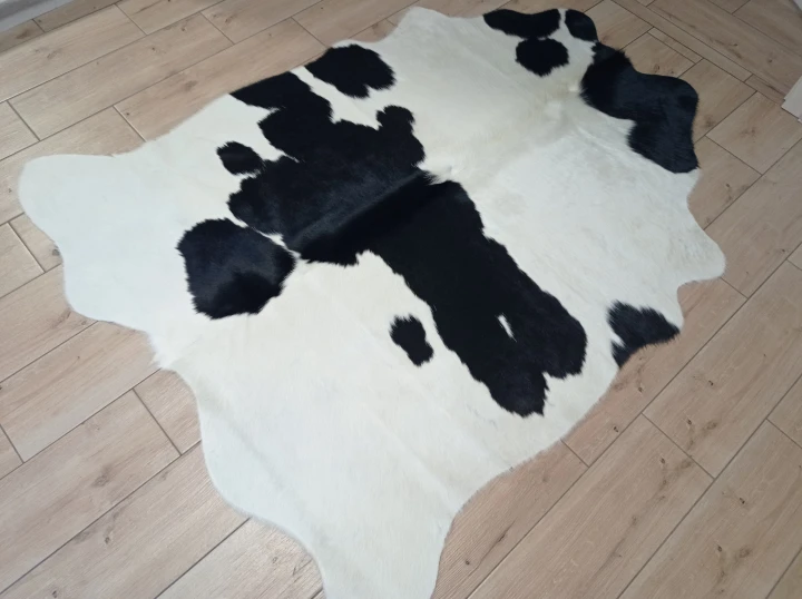 Naturalna skóra bydlęca ŁACIATA CZARNO-KREMOWA 170x140 cm rozłożona w dużym salonie  - dekoracyjneskory.pl