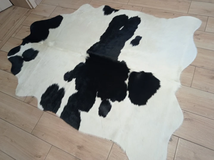 Naturalna skóra bydlęca ŁACIATA CZARNO-KREMOWA 170x140 cm rozłożona w dużym salonie  - dekoracyjneskory.pl